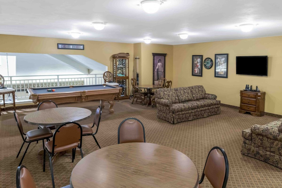 A cozy lounge area with tables and chairs, featuring a sofa and various decorations on the walls.