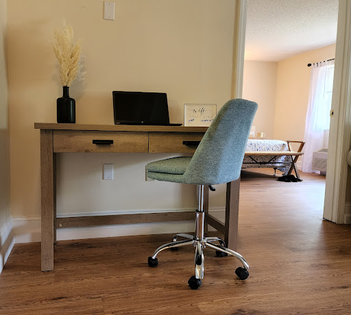A modern workspace featuring a wooden desk with a stylish chair, set in a cozy room.