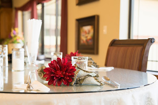 A beautifully arranged dining table featuring red flowers and elegant glassware.