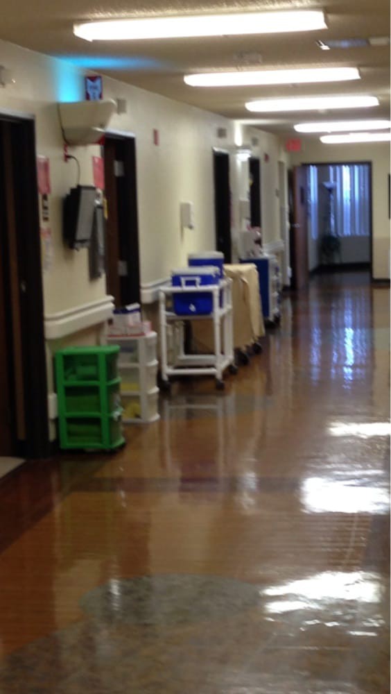 A hospital hallway with medical carts and equipment lined up.