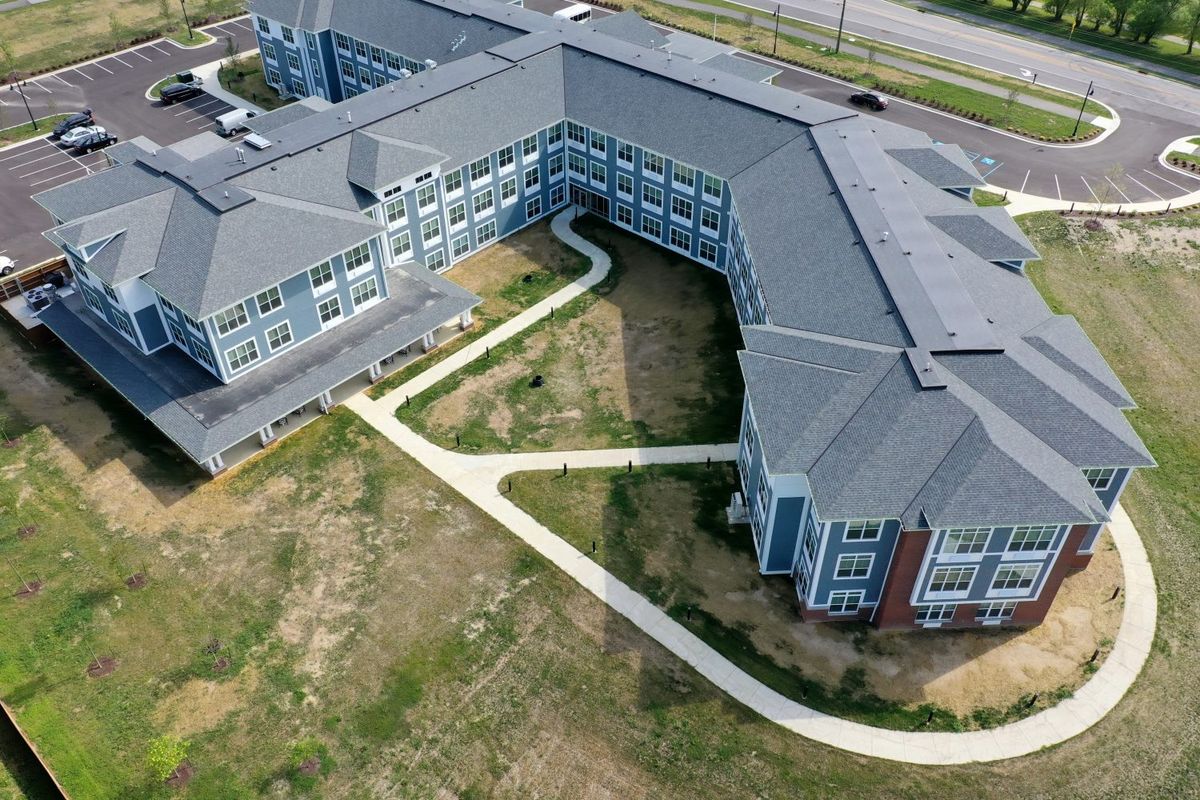 Aerial view of a large building complex with multiple pathways and surrounding green areas.