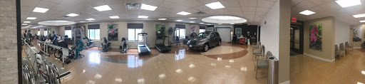 A unique gym setup featuring exercise equipment alongside a parked car.