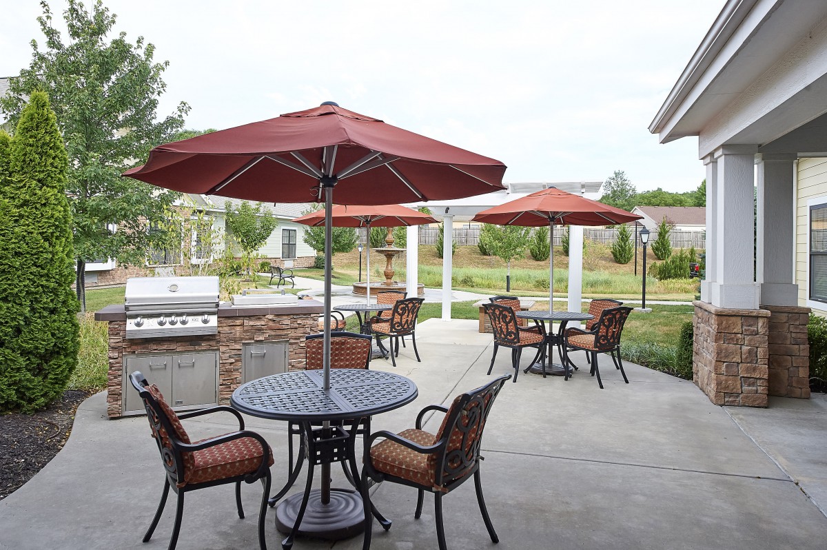 A peaceful outdoor patio area with tables, chairs, and umbrellas.