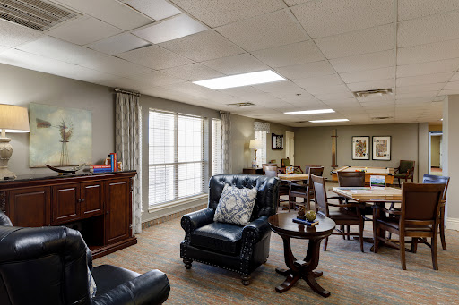 A cozy living space featuring comfortable seating, natural light streaming through large windows, and a warm ambiance.