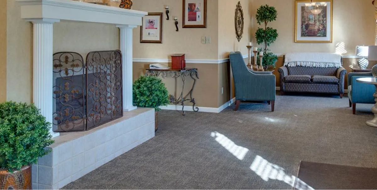 A cozy living room with a fireplace, comfortable chair, and elegant decor.