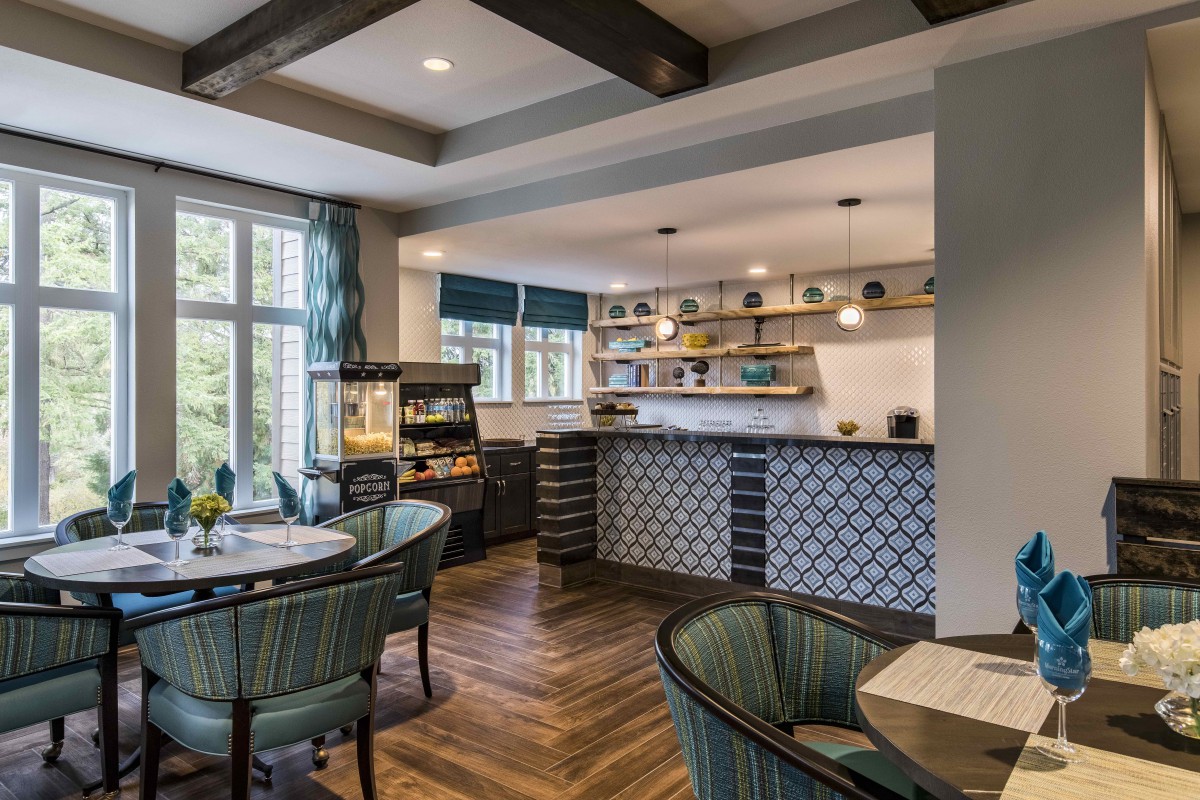 A modern and cozy kitchen with an open dining area, featuring ample natural light, wooden flooring, and stylish decor.