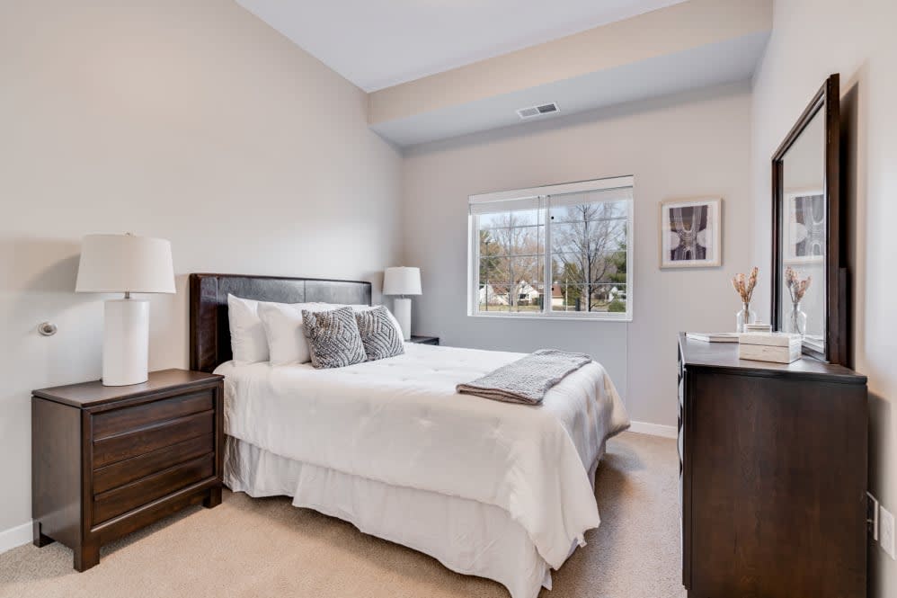 A well-lit bedroom with modern decor and a comfortable bed.