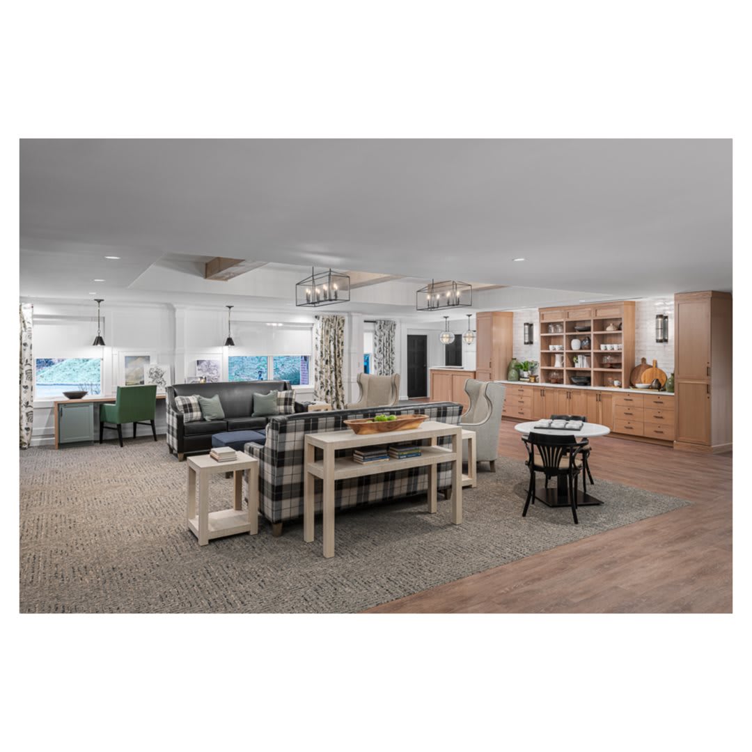 A spacious, modern open-concept living area featuring a dining table, lounge seating, and an adjacent kitchen.