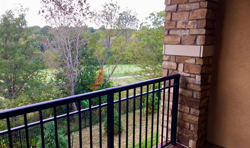 A balcony overlooking a natural landscape with trees and greenery.