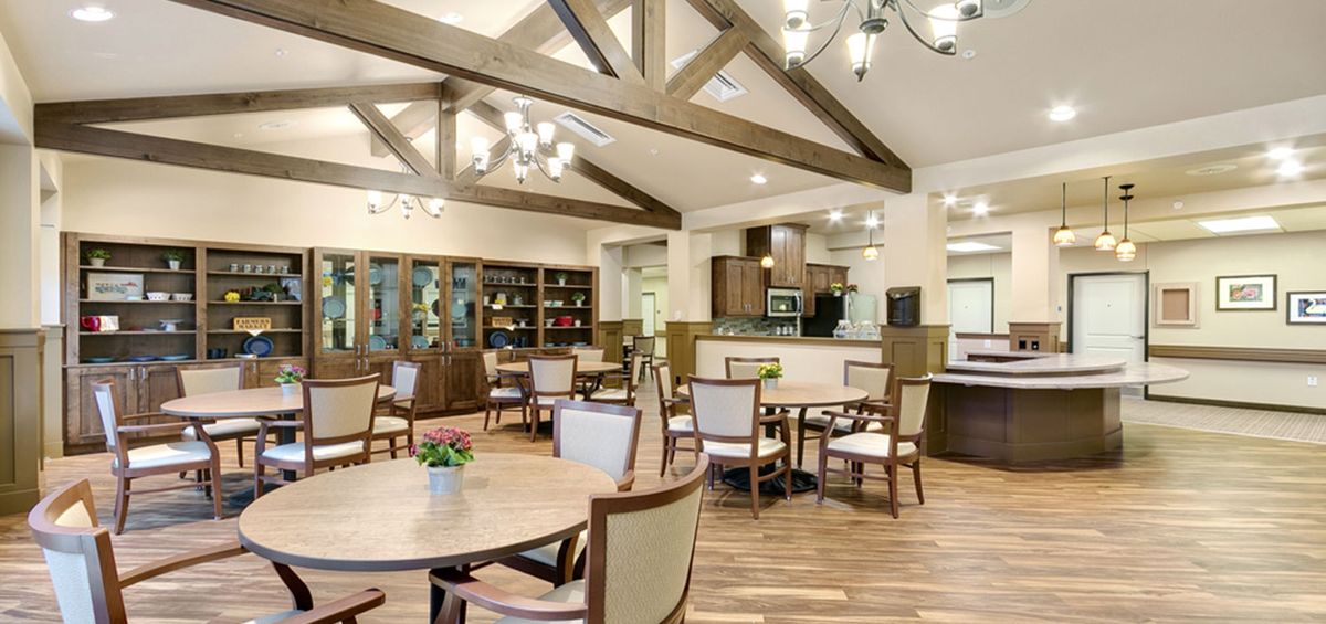 A modern dining area with wooden beams and elegant chandeliers.