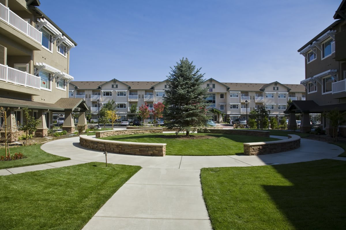 A view of a residential apartment complex with well-maintained lawns and pathways.