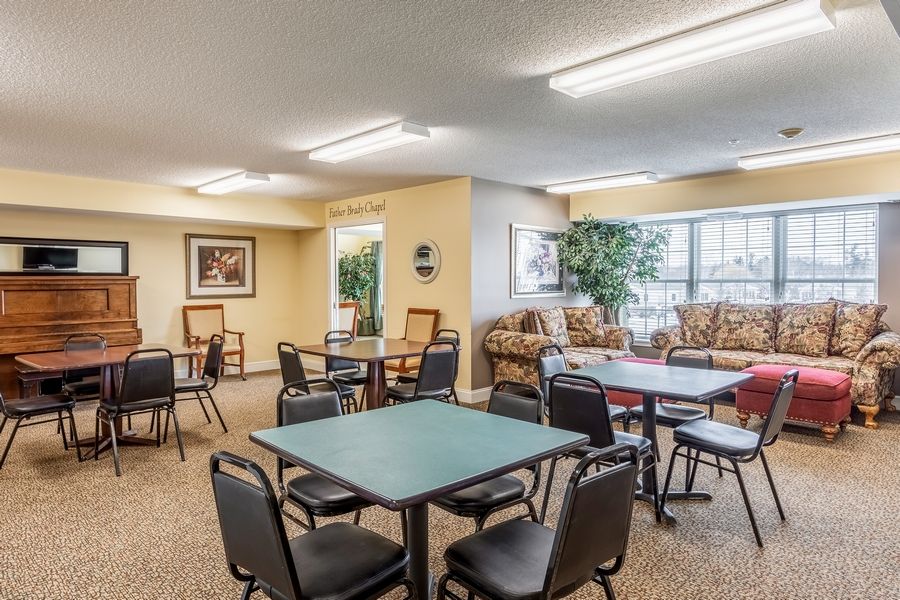 A cozy lounge area with multiple seating arrangements, tables, and decor.