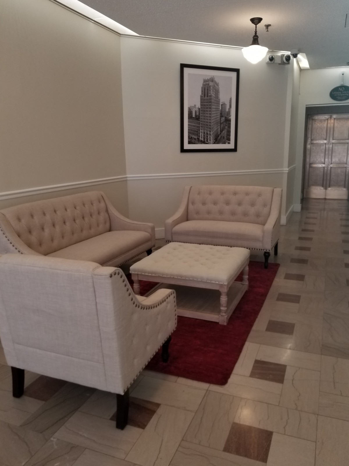 A cozy lobby area featuring two sofas, a coffee table, and a framed picture on the wall.
