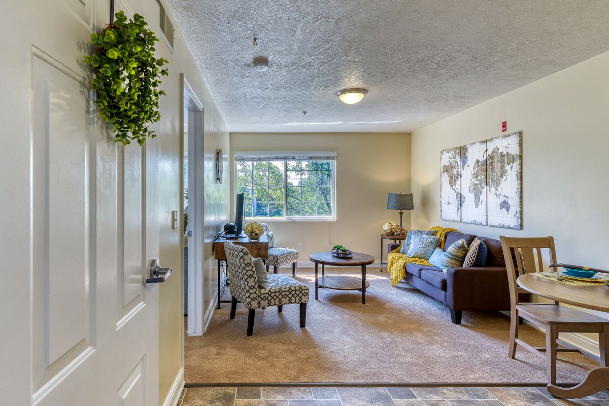 A cozy living room with a sofa, table, and decorative artwork on the wall.