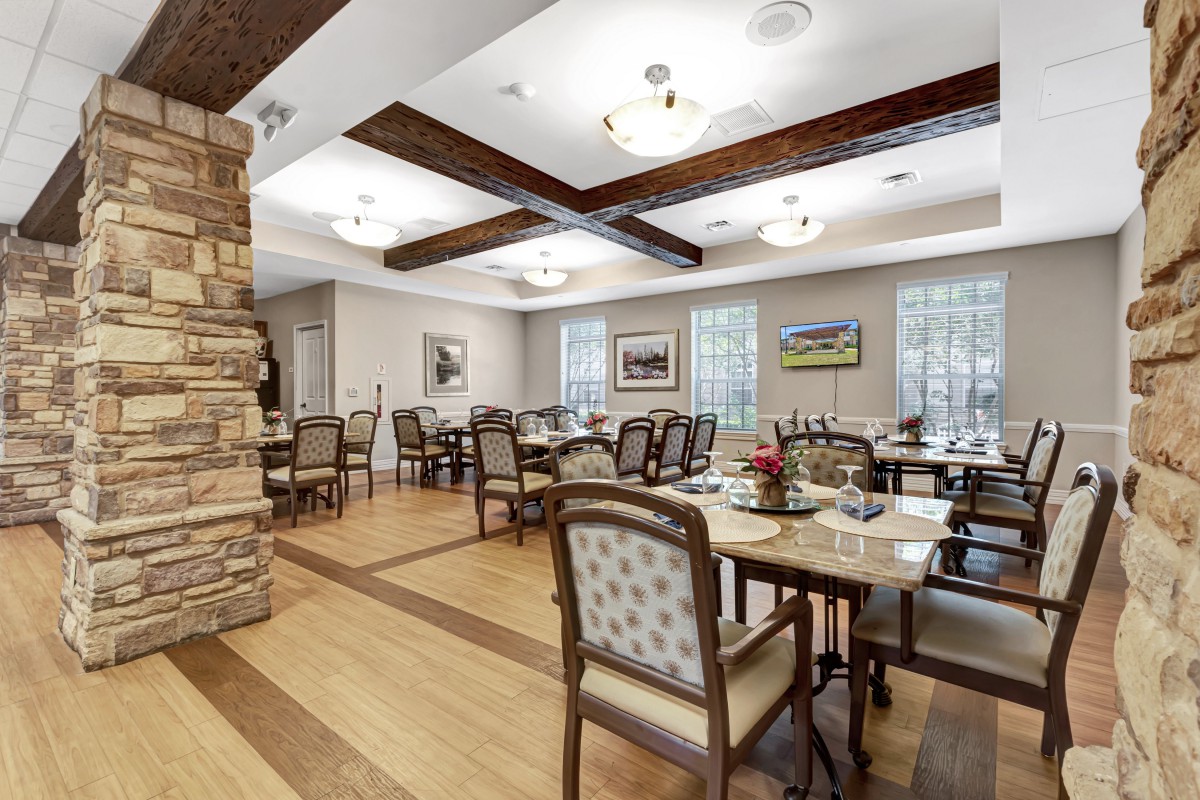 A well-lit dining room with elegant furniture and wooden floors.