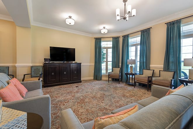 A cozy living room featuring contemporary furniture and decor, with a television and comfortable seating.