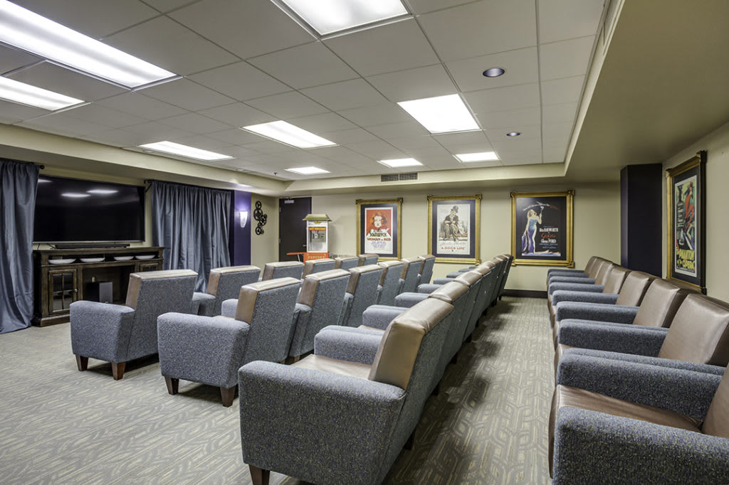 A well-designed home theater room with comfortable seating and movie posters on the walls.