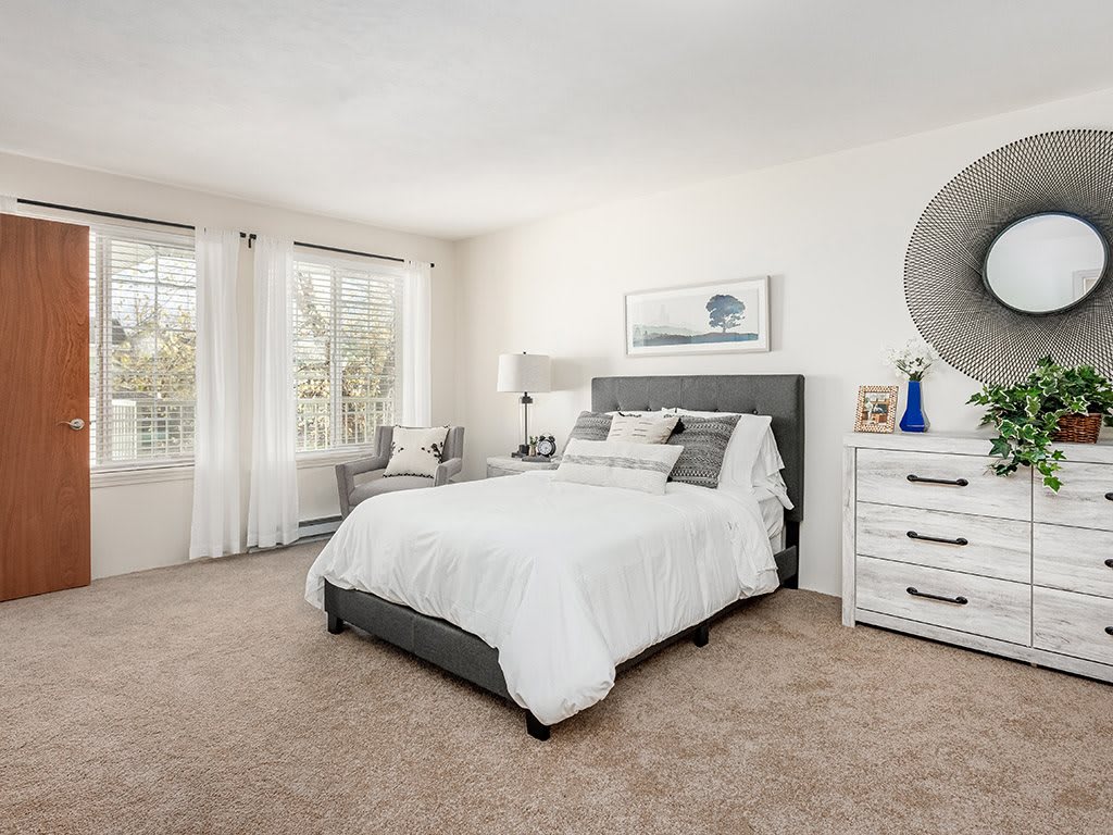 A modern, cozy bedroom with a white theme and natural light.
