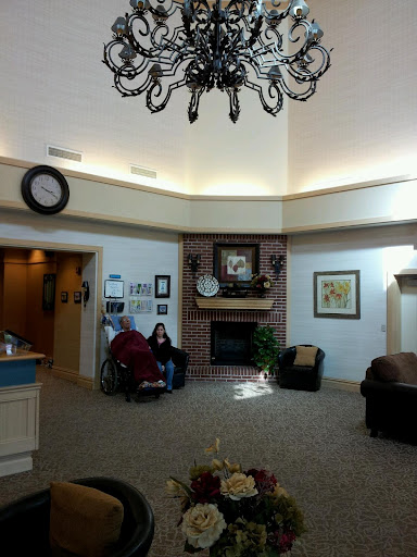 A cozy lobby featuring comfortable seating, a decorative fireplace, and elegant lighting.