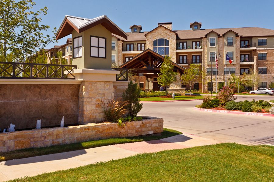 A modern residential apartment complex with landscaped surroundings and a welcoming entrance.