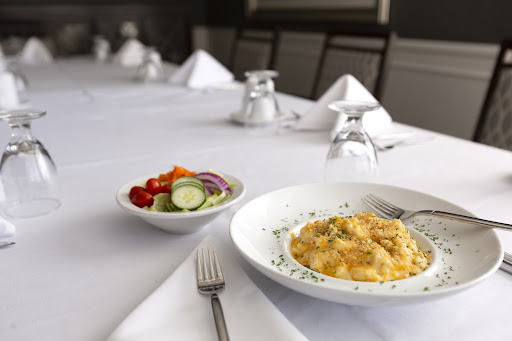 A beautifully set dining table featuring a delicious plate of pasta and a fresh salad.