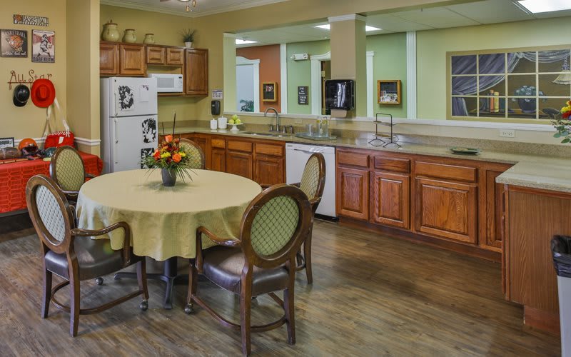 A spacious kitchen featuring wooden cabinets and a round dining table with chairs.