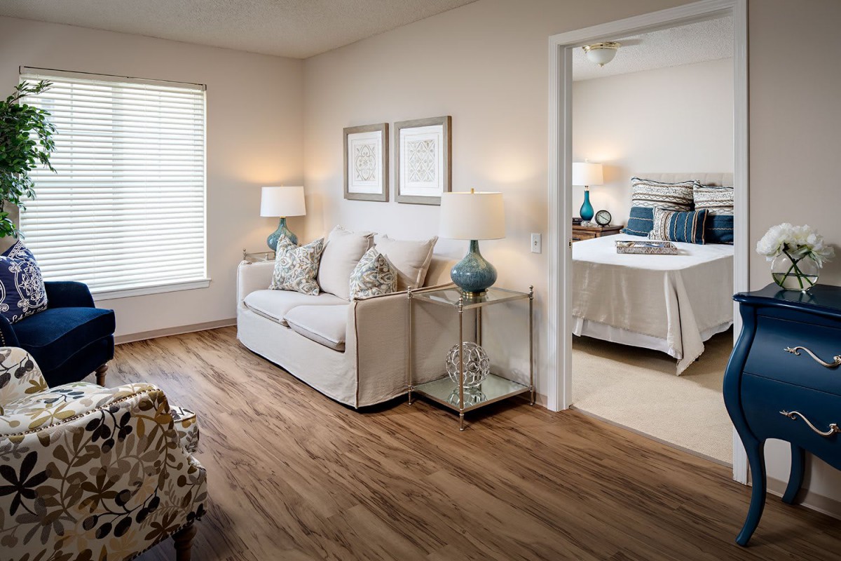 A cozy living room leads into a well-decorated bedroom, featuring comfortable furniture and stylish decor.