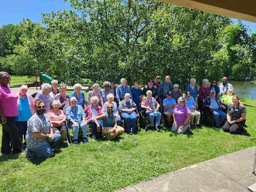 A joyful gathering of seniors enjoying a sunny day in the park.