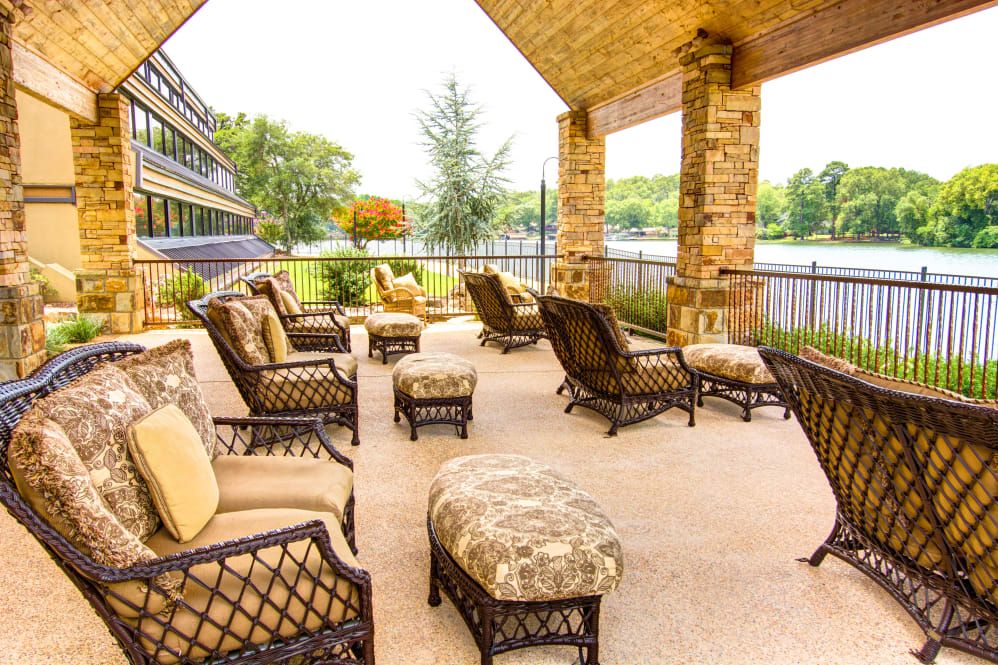Cozy outdoor patio with comfortable seating and a lake view.