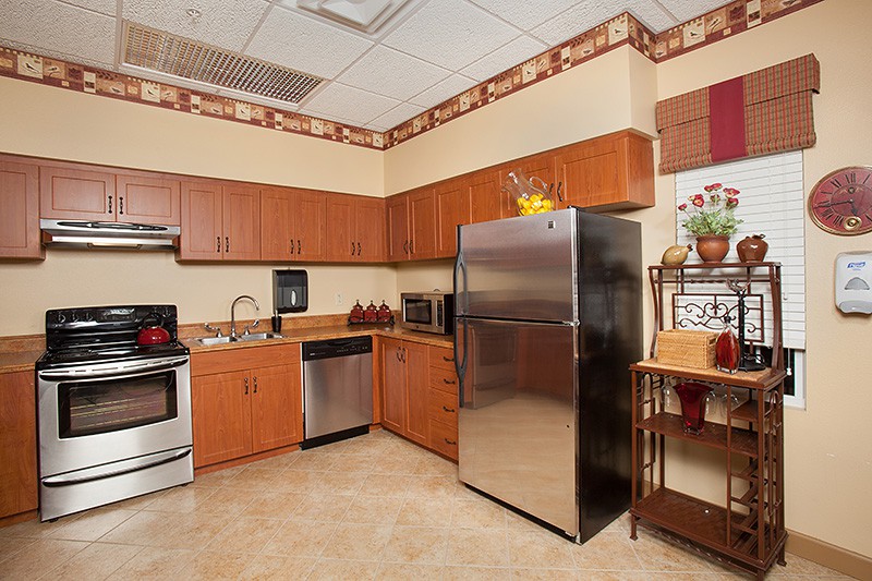 A modern kitchen with wooden cabinets, stainless steel appliances, and a cozy design.