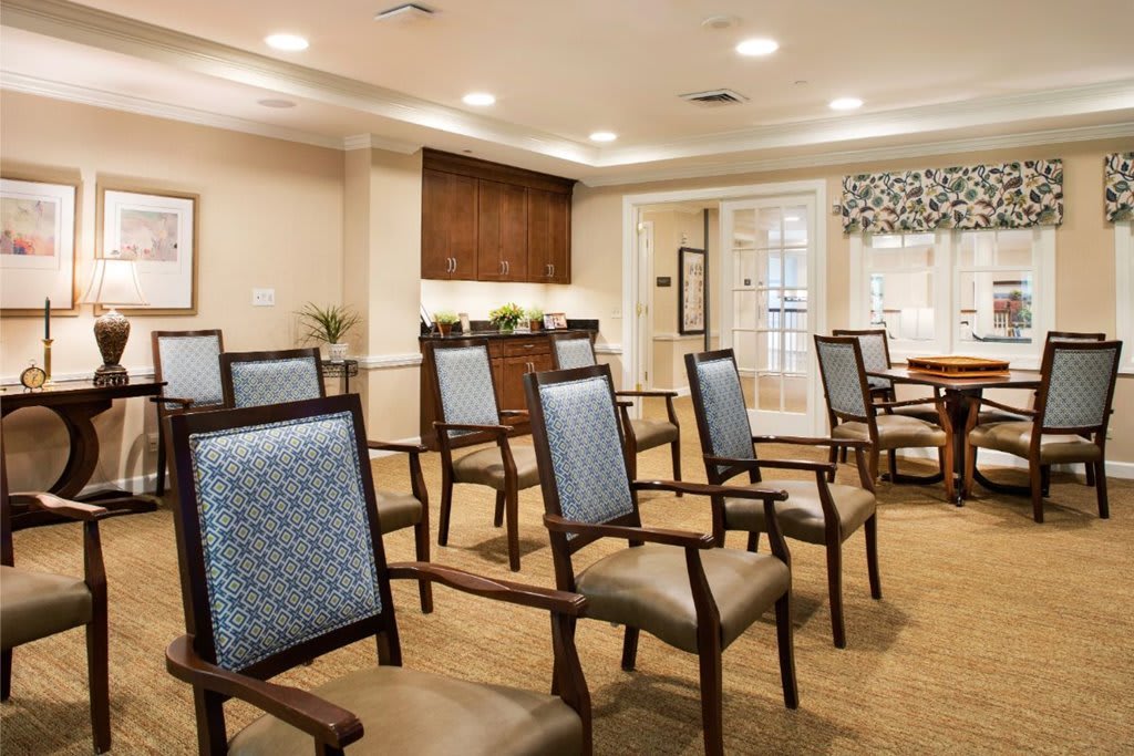 A well-organized conference room with rows of comfortable chairs and warm lighting.
