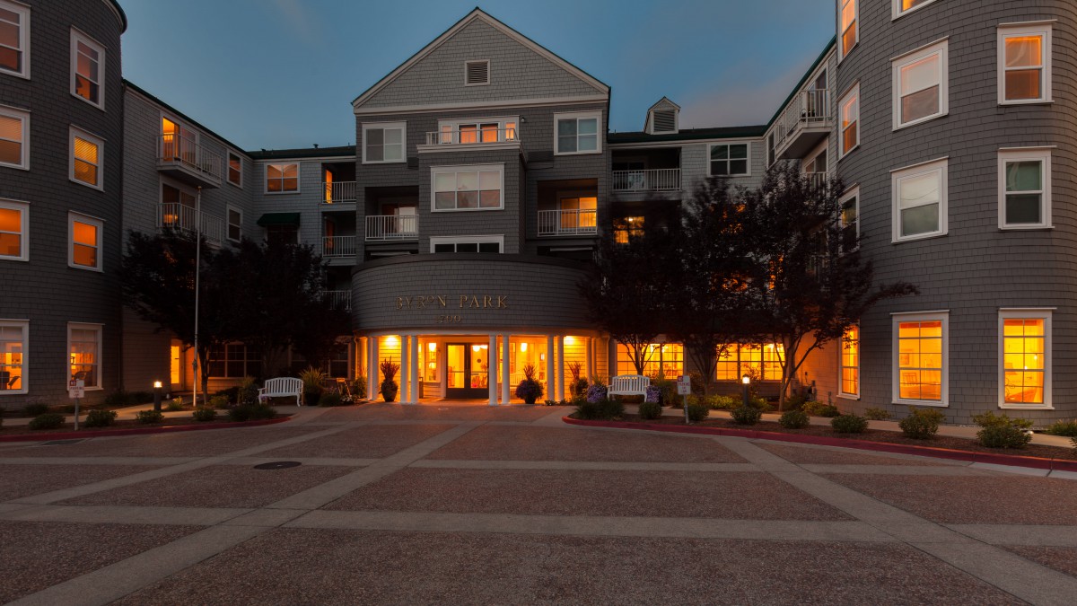 An illuminated apartment building entrance during the evening.