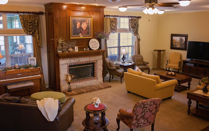 A cozy living room with a fireplace, sofas, and elegant decor.