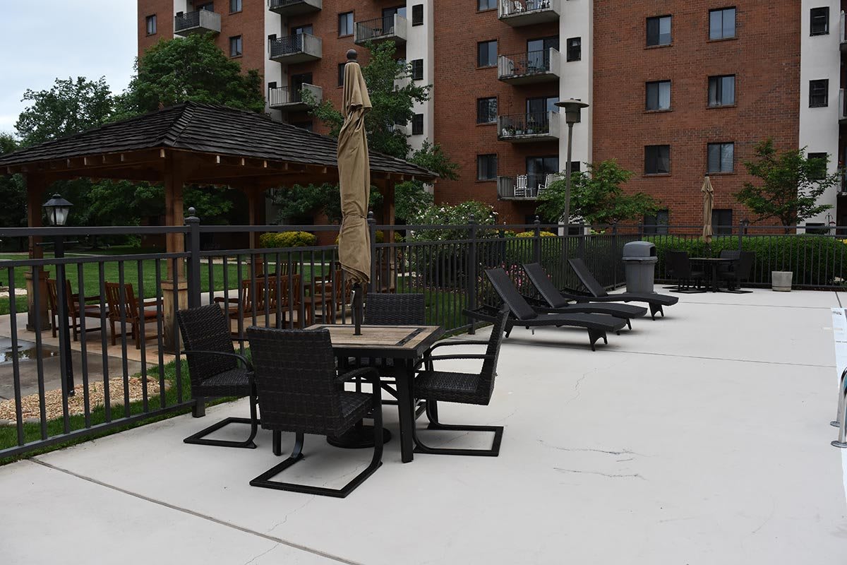 Outdoor patio furniture near an apartment building pool area.