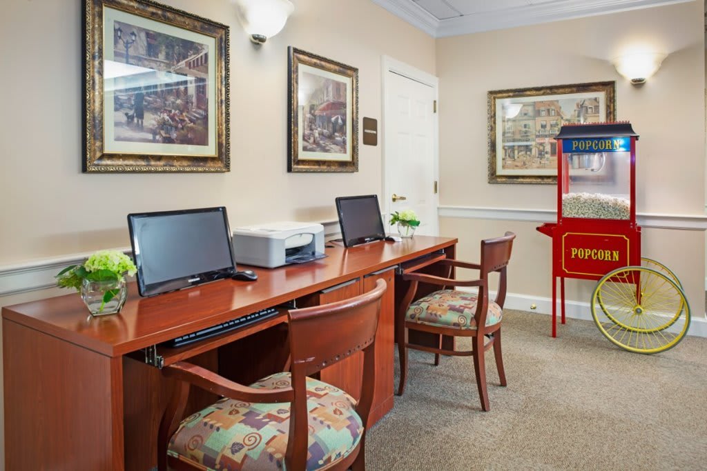 A small office area with desks, computers, and a popcorn machine in the corner.