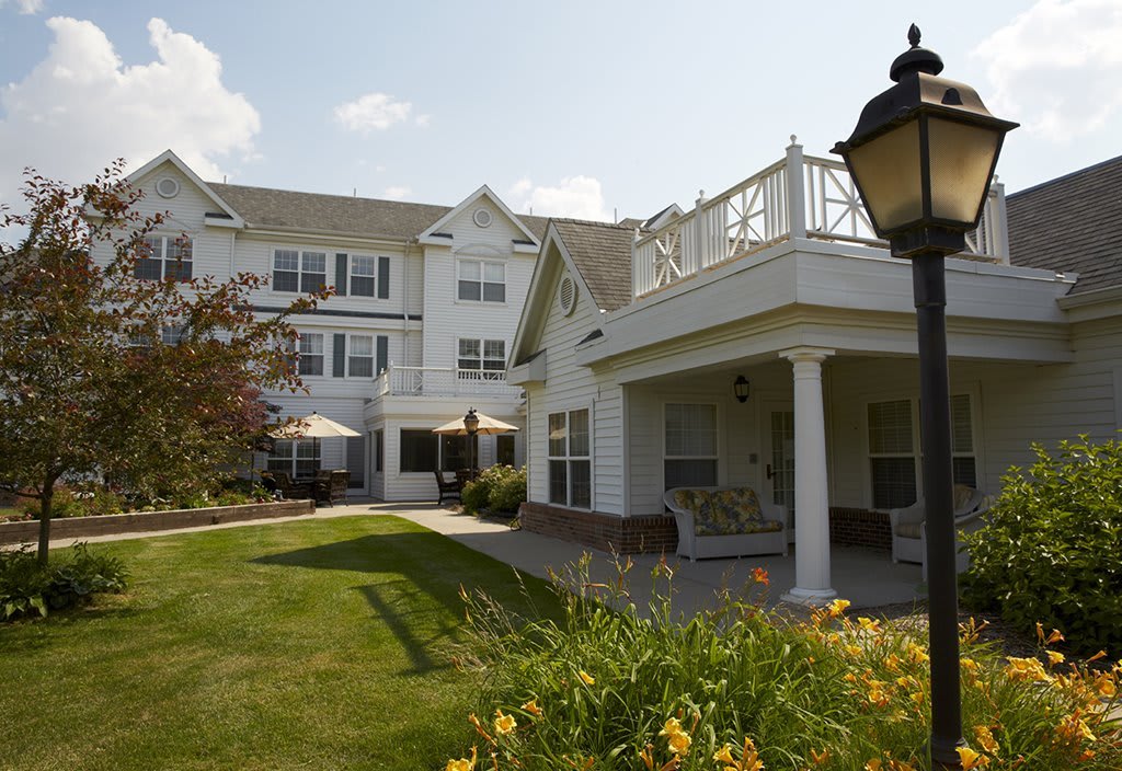 A picturesque view of a residential building with a well-maintained lawn and vibrant landscaping.