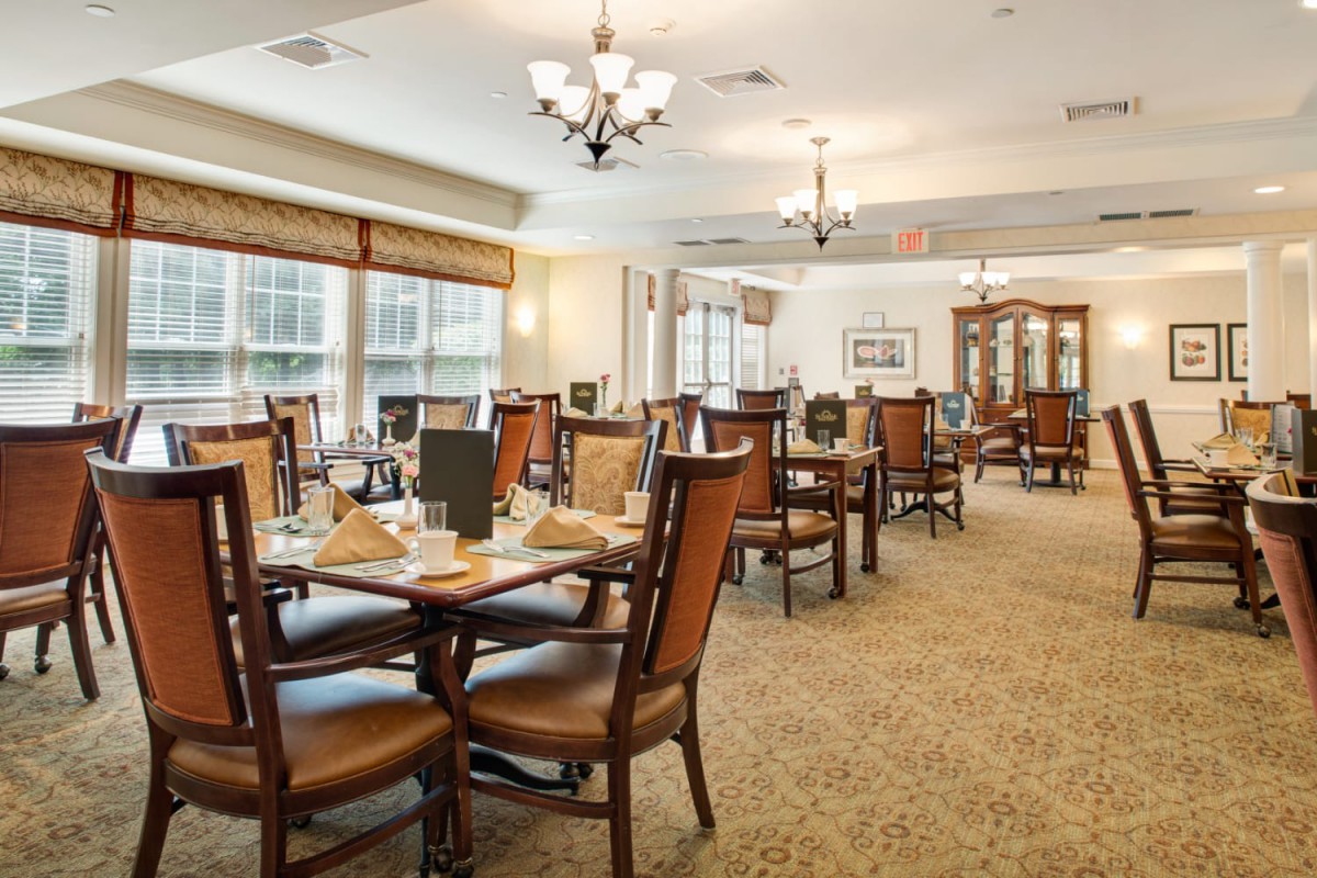A spacious and elegantly decorated dining room with multiple tables set for dining.