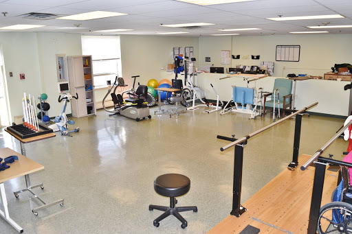 A well-equipped physical therapy gym featuring various exercise machines and rehabilitation tools.