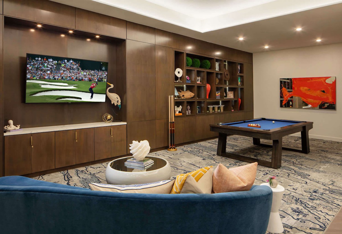 A cozy living room with a television, pool table, and stylish decor.