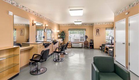 An interior view of a modern hair salon with multiple styling stations and a comfortable waiting area.