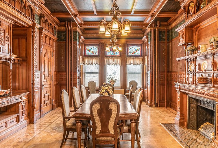 A beautifully designed vintage dining room with elegant wooden interiors and a classic chandelier.