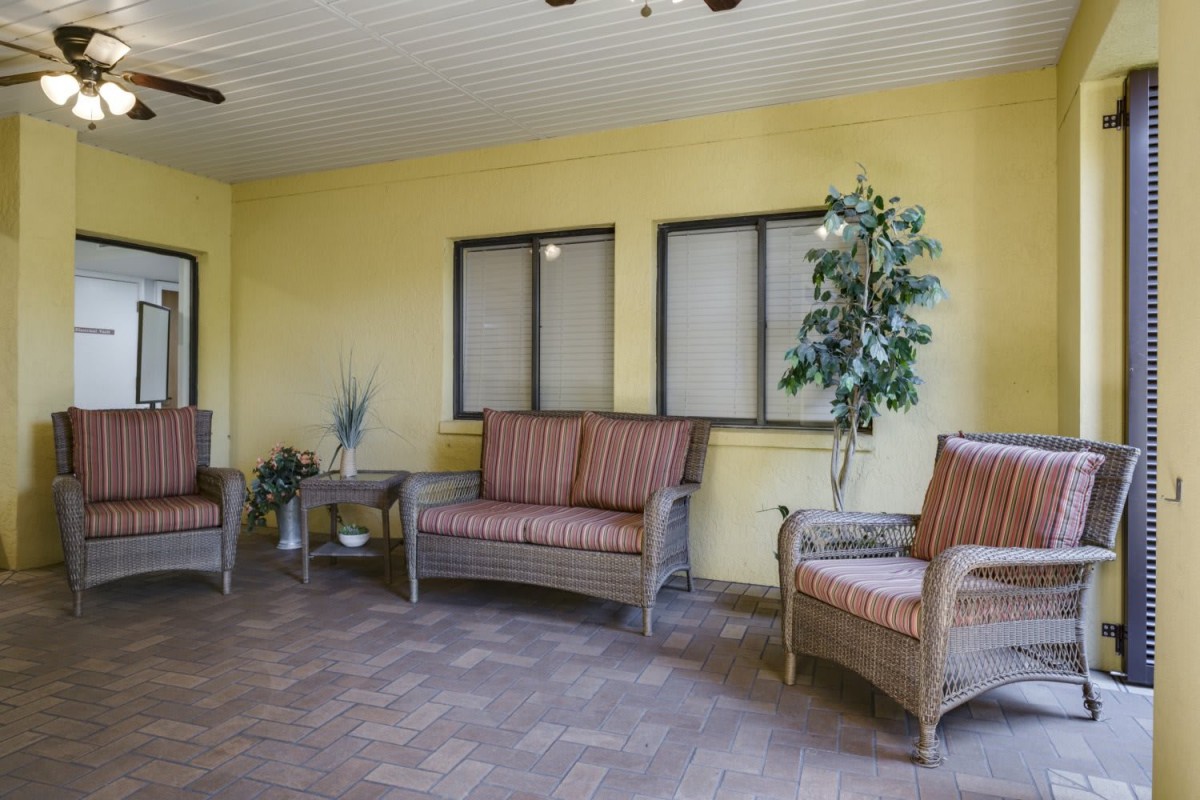 A cozy indoor seating area with wicker furniture and a potted plant.