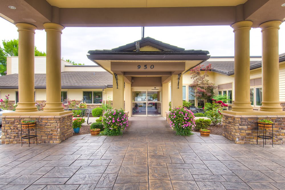 Elegant entrance to a building with landscaped gardens and flower arrangements.