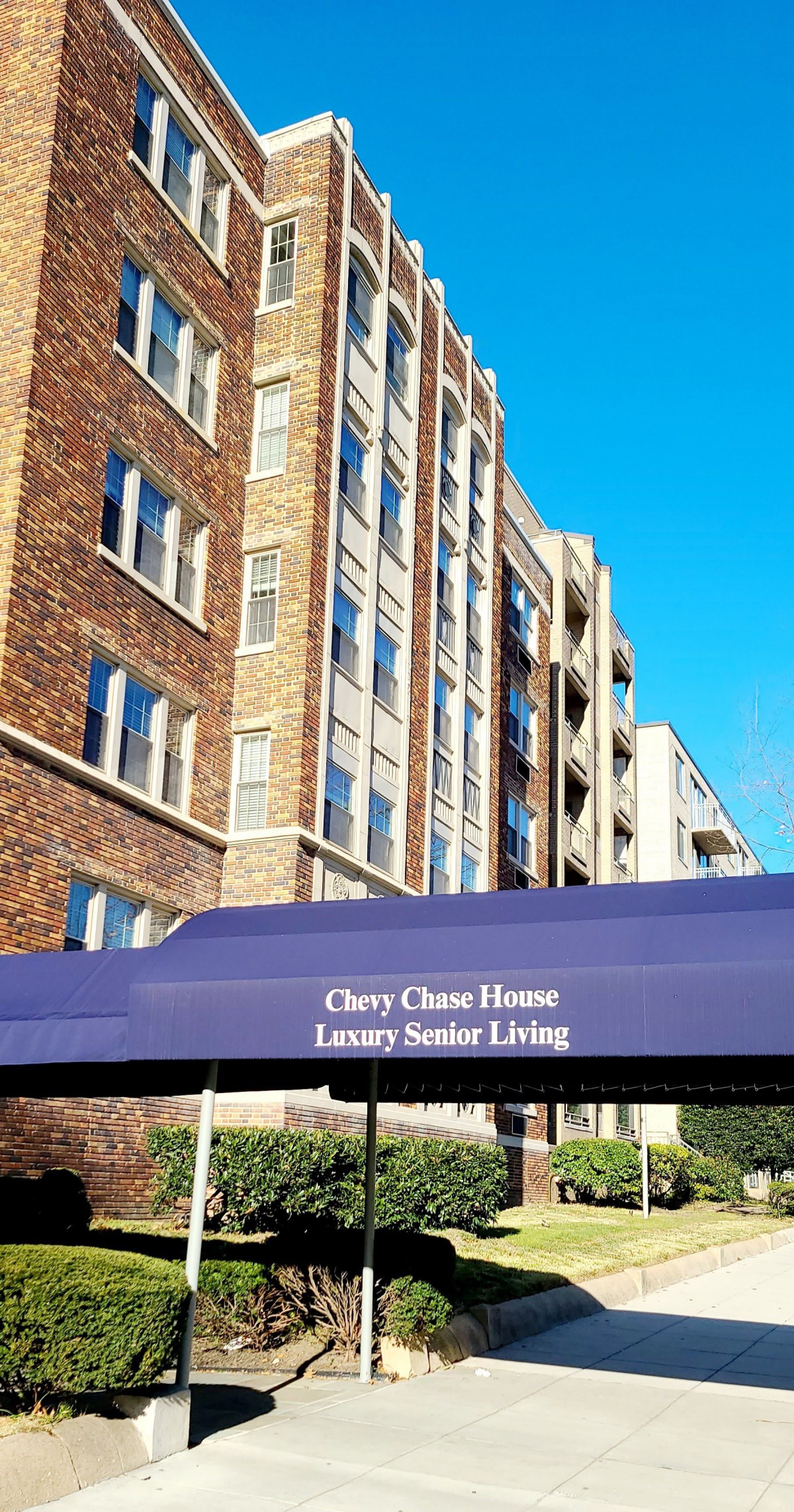 A luxury senior living building with a prominent awning reading 'Chevy Chase House Luxury Senior Living'.