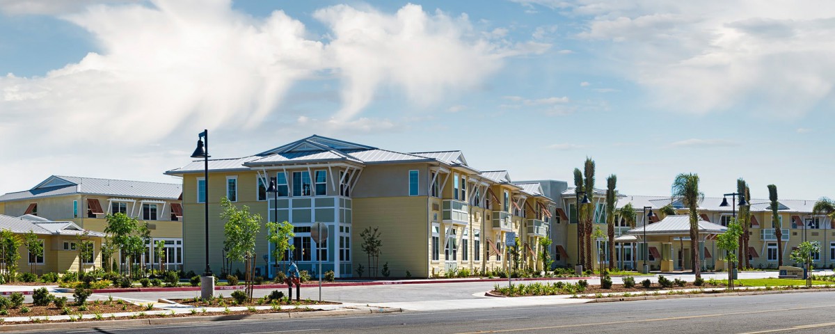 A modern residential building with a stylish architectural design under a clear, sunny sky.