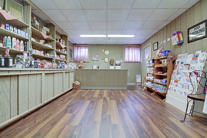A cozy gift shop interior with shelves filled with various products and a wooden counter.