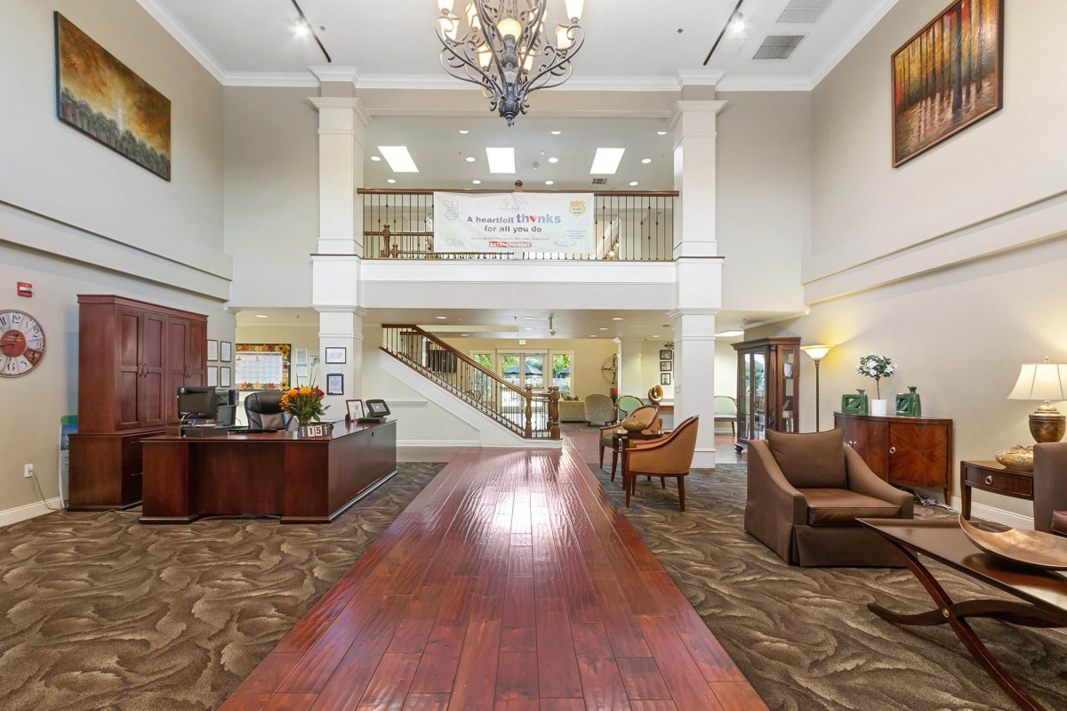 Spacious and elegant lobby with a central chandelier and comfortable seating.