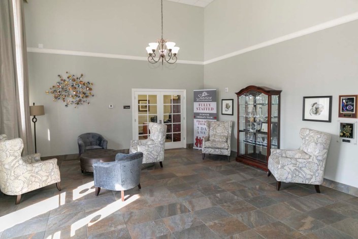 A cozy lobby area with comfortable seating, a chandelier, and decorative elements.