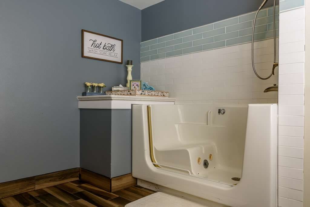 A modern bathroom featuring a walk-in tub with stylish blue and white tiles, providing accessibility and comfort.