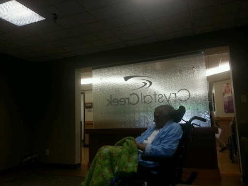 A patient waiting in a medical facility, highlighted by the transparent signage in the background.